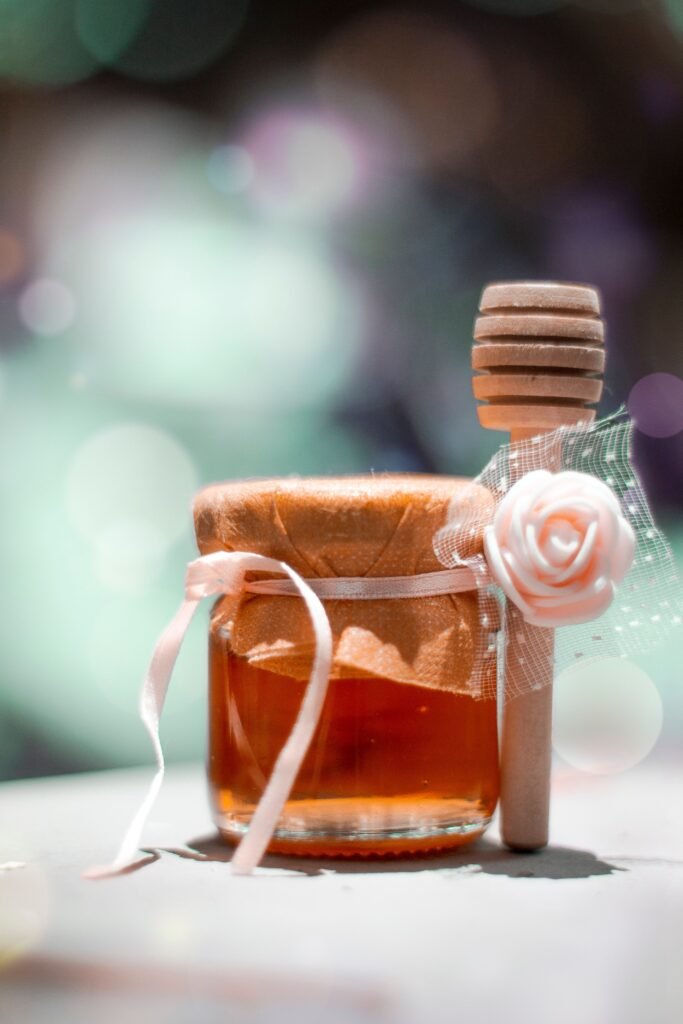 Tarro de miel artesanal decorado con lazo y cuchara de madera, ideal para regalar